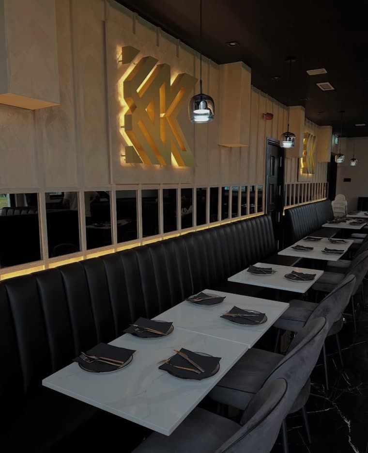 Backlit brass Kashmiri Karahi monogram above fixed leather banquettes